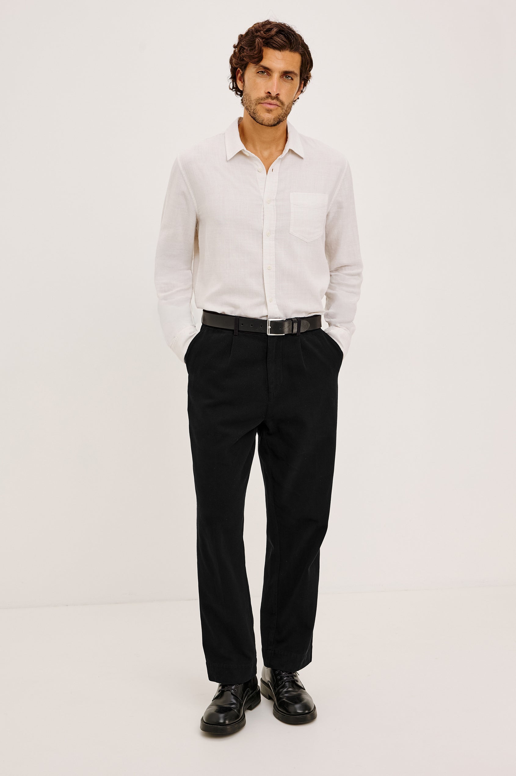 Ezra Pant in Brushed Cotton Twill With Relaxed Fit, Single Front Pleats, Ankle-Length Hem, Zip Fly, Side Pockets, and Back Double-Welt Pockets in Black Colorway - Full Body Front View Featured on Model