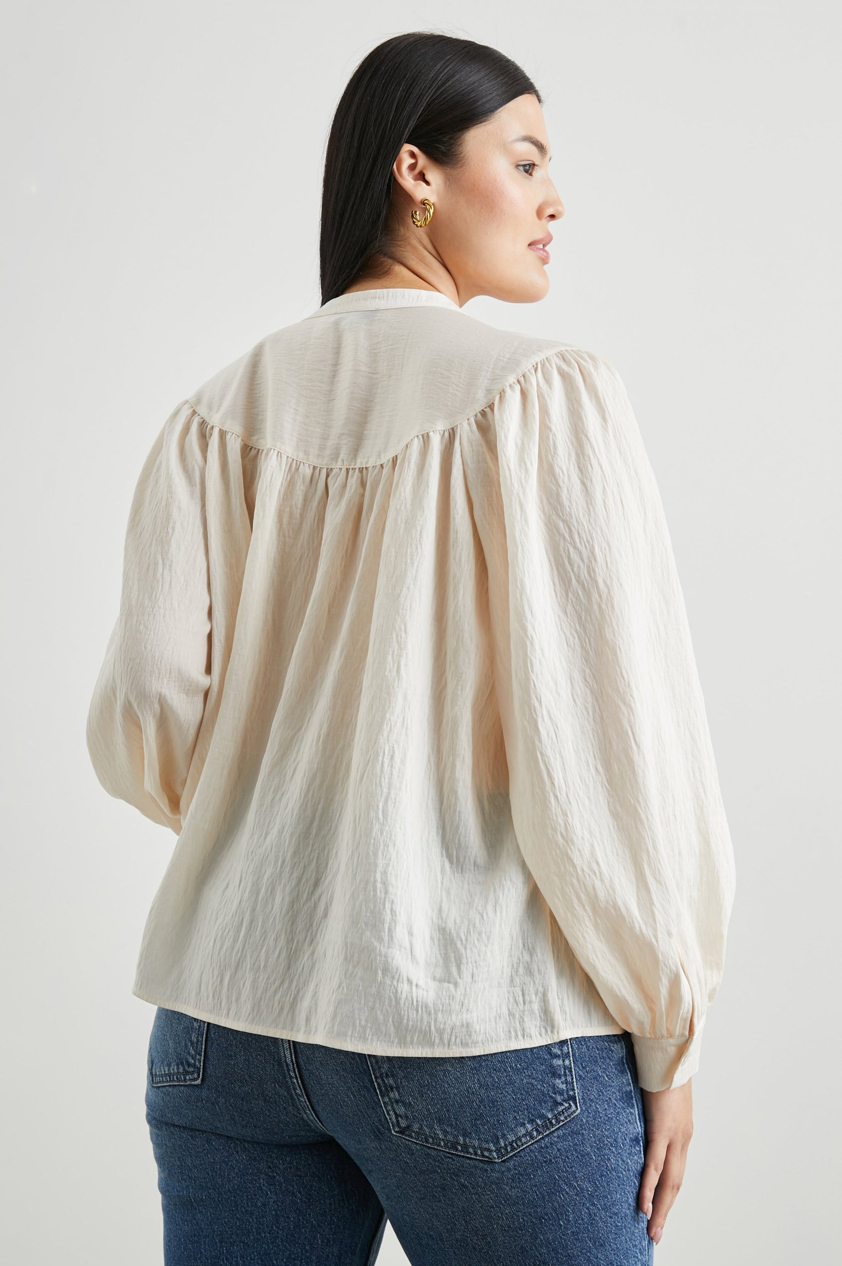 Fable Long Sleeve Top with a V Neck with a Placket, Buttoned Cuffs, and Pleating Down From the Yoke in Lotus Colorway - Back View Featured on Model 