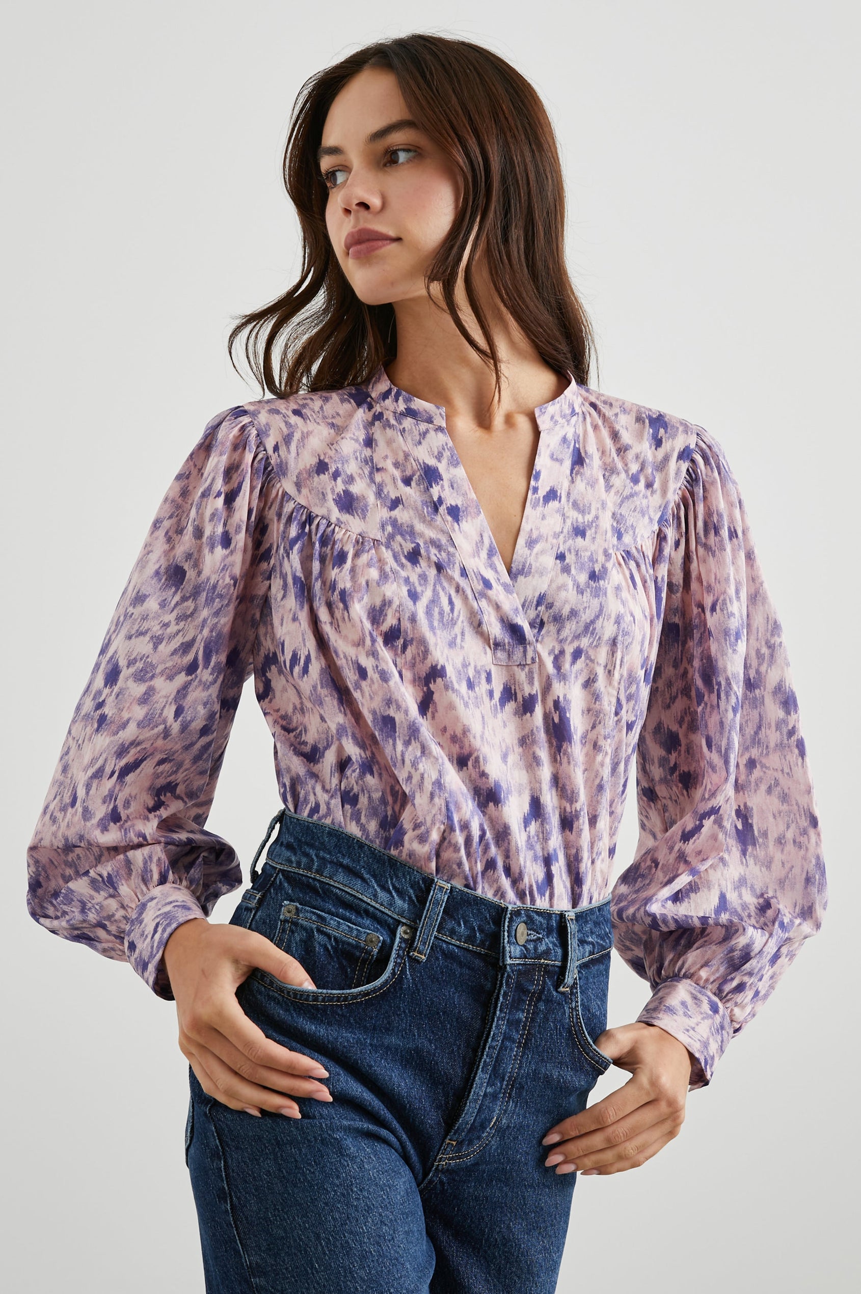 Fable Long Sleeve Top with a V Neck with a Placket, Buttoned Cuffs, and Pleating Down From the Yoke in Pink Ikat Colorway, Diffused Purple Spots on Pink - Front Tucked View Featured on Model 