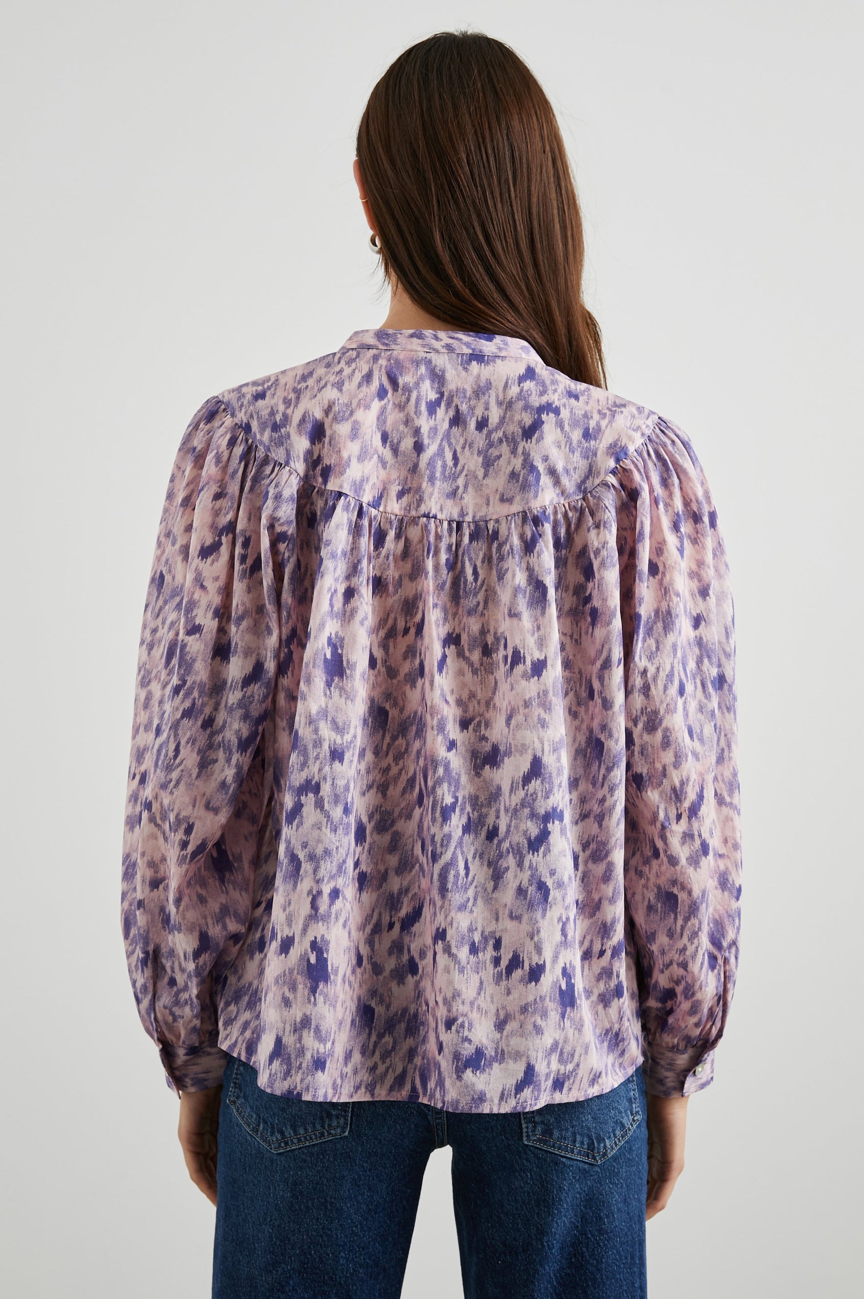 Fable Long Sleeve Top with a V Neck with a Placket, Buttoned Cuffs, and Pleating Down From the Yoke in Pink Ikat Colorway, Diffused Purple Spots on Pink - Back View Featured on Model 