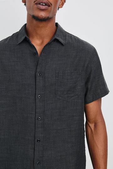 Fairfax Short-Sleeve Button Up with a Chest Patch Pocket in Black Chambray Colorway - Front View Featured on Model