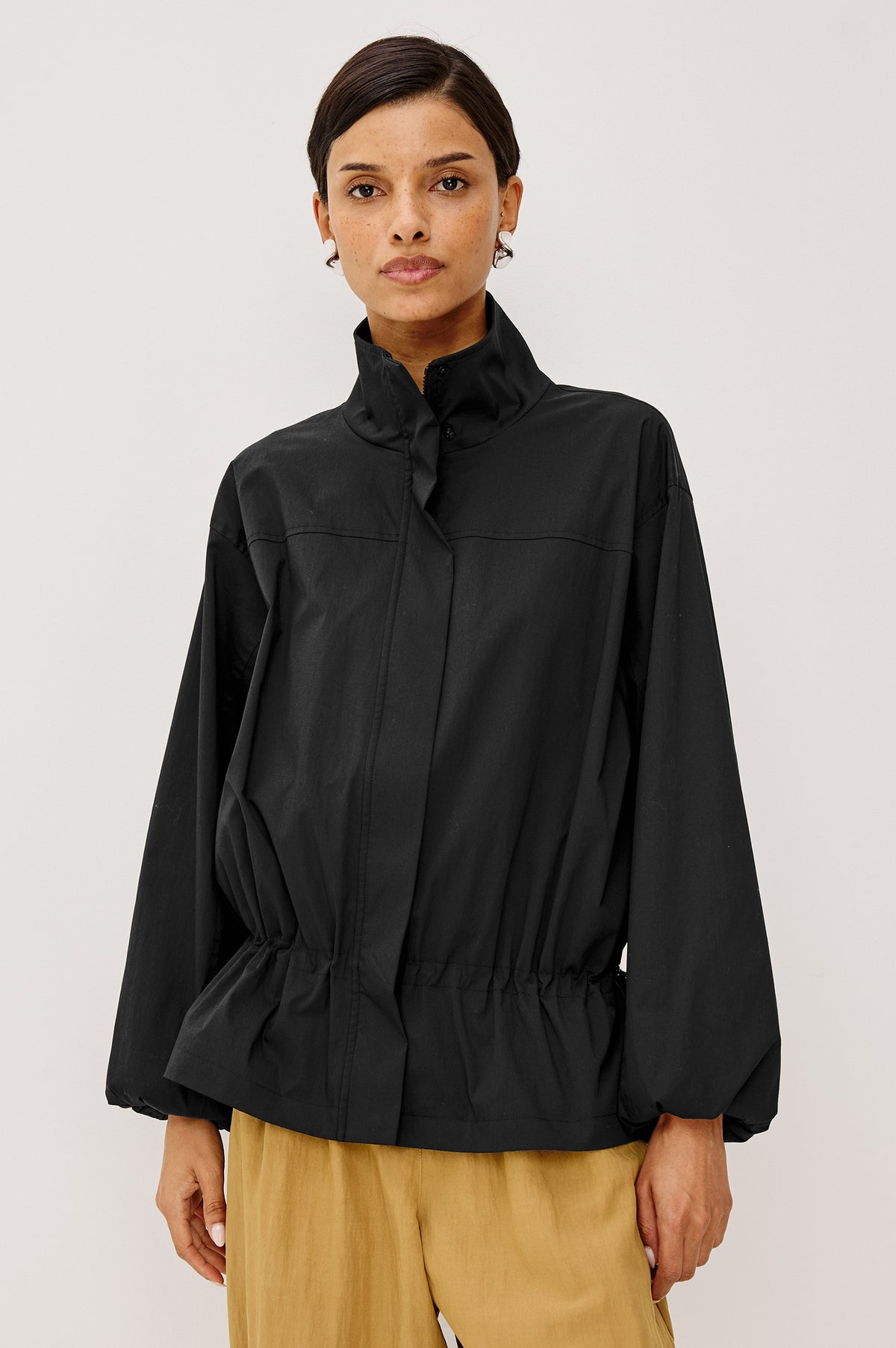 Felix Jacket in Cotton Nylon With Snap-Button Stand Collar, Front Zip-and-Snap Closures, Elastic Cuffs, Long Sleeves, and Drawcord Sides in Black Colorway - Upper Body Front View Featured on Model