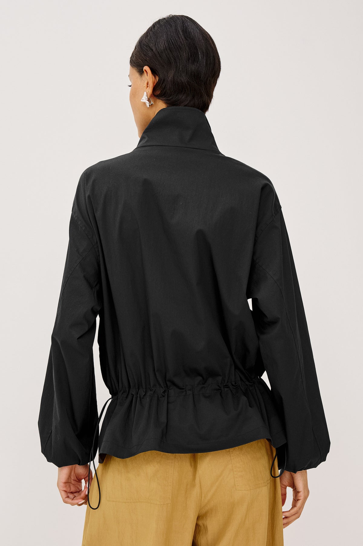 Felix Jacket in Cotton Nylon With Snap-Button Stand Collar, Front Zip-and-Snap Closures, Elastic Cuffs, Long Sleeves, and Drawcord Sides in Black Colorway - Upper Body Back View Featured on Model