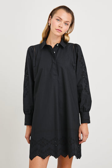 Fernanda Long-Sleeve Mini Dress with Button Cuffs, a Collar, a Placket with Buttons, a Scalloped Hem, a Floral Eyelet Design on the Sleeves and a Floral and Geometric Eyelet Design on the Hem in Black Eyelet Colorway - Front View Featured on Model