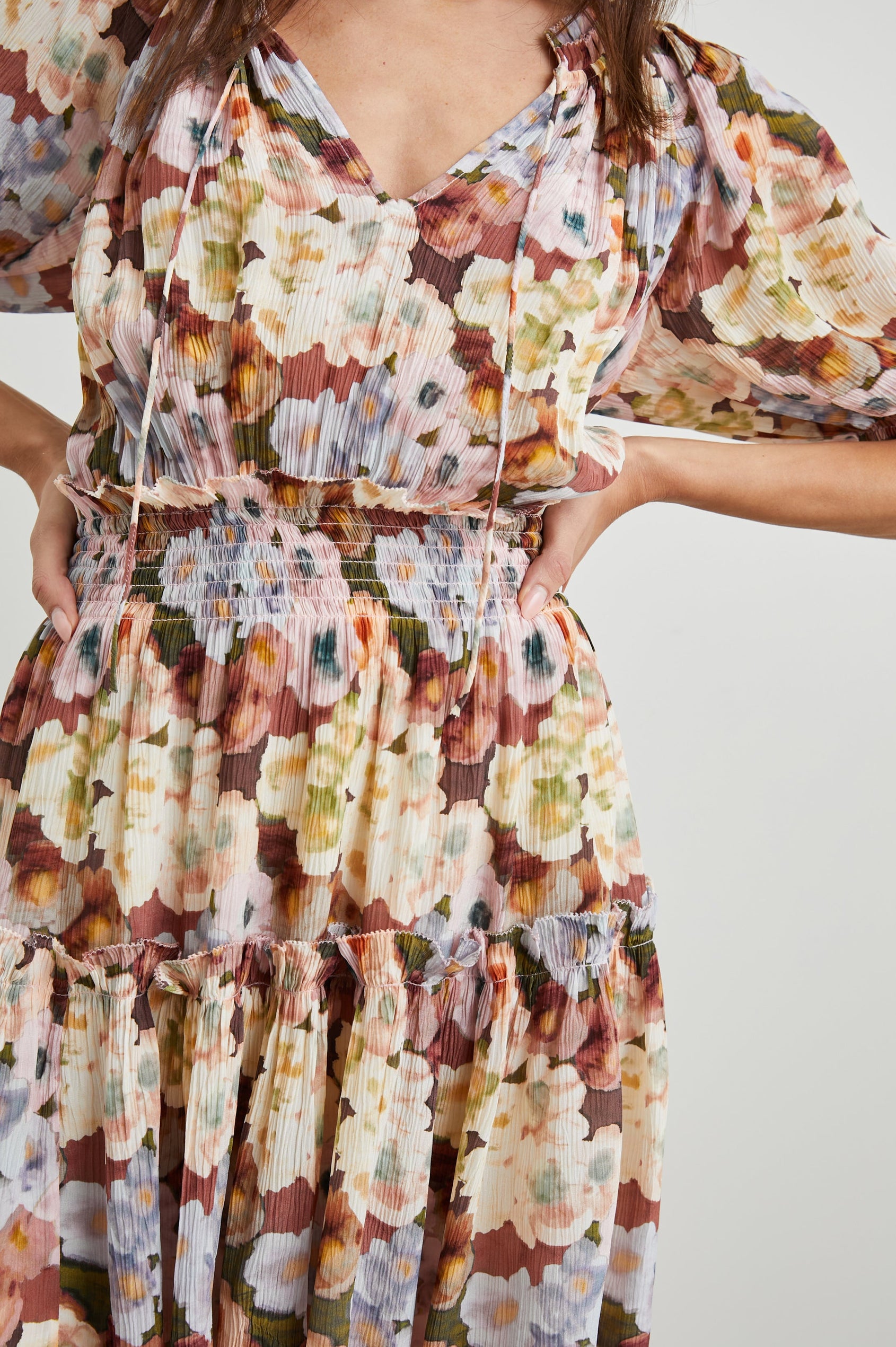 Fiorella Short-Sleeve, Above-Knee Dress with a Shirred Collar and Waist, V-neckline with Ties, Puff Sleeves and a Tiered Skirt in Painted Floral Colorway, with browns, yellows and blues - Front View Featured on Model