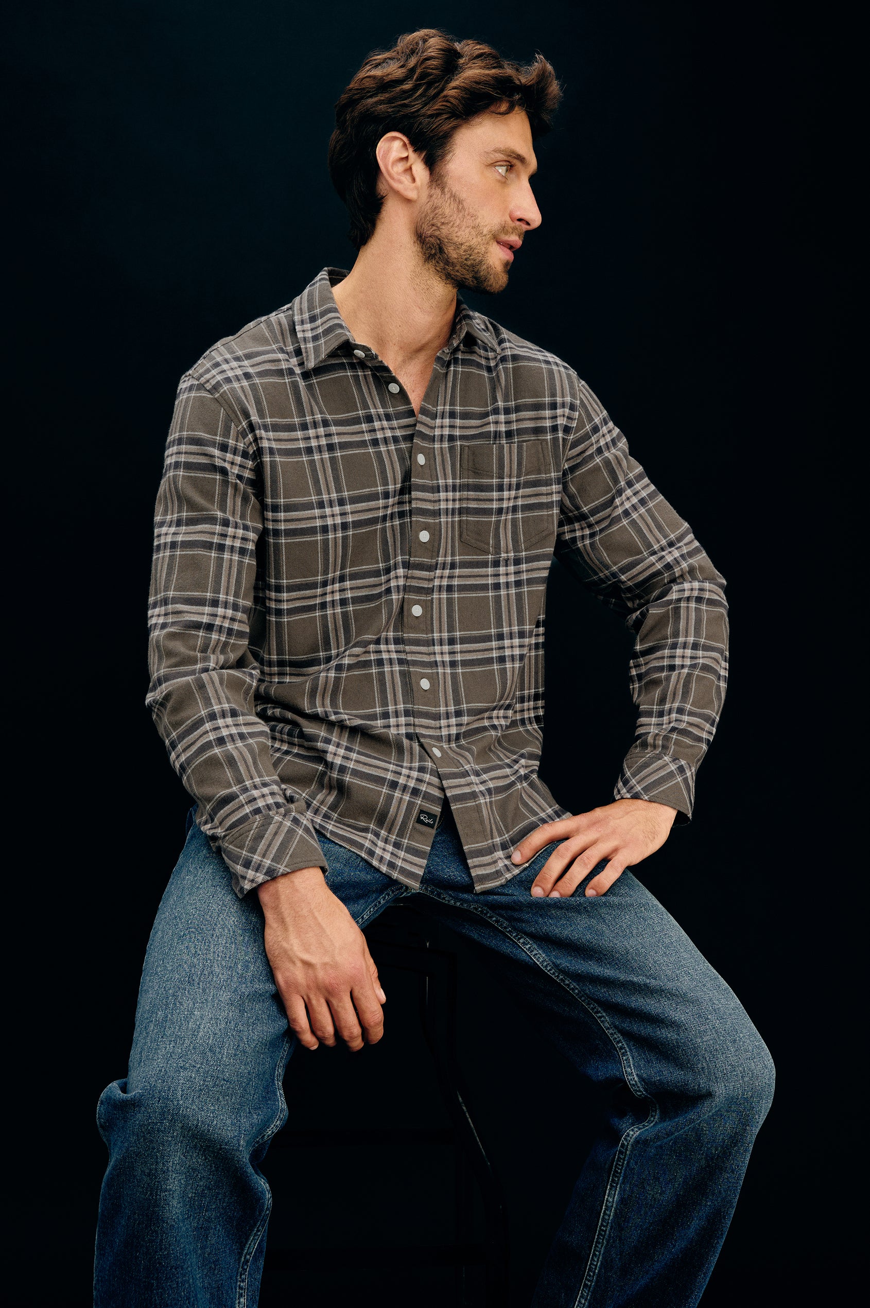 Forrest Long-Sleeve Button Up with a Chest Patch Pocket in Driftwood Coal Colorway, a Brown, Green and Charcoal plaid - Front Full Body View Featured on Seated Model