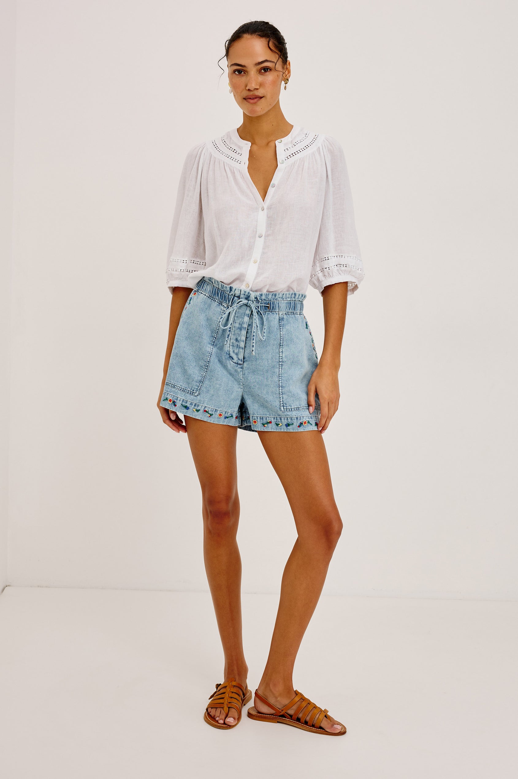 Foster Short in Cotton-Lyocell Denim With High-Rise, Paperbag Waist, Adjustable Corded Drawstring, Front Pockets, and Back Welt Pockets in Indigo Floral Embroidery Colorway - Full Body Front View Featured on Model
