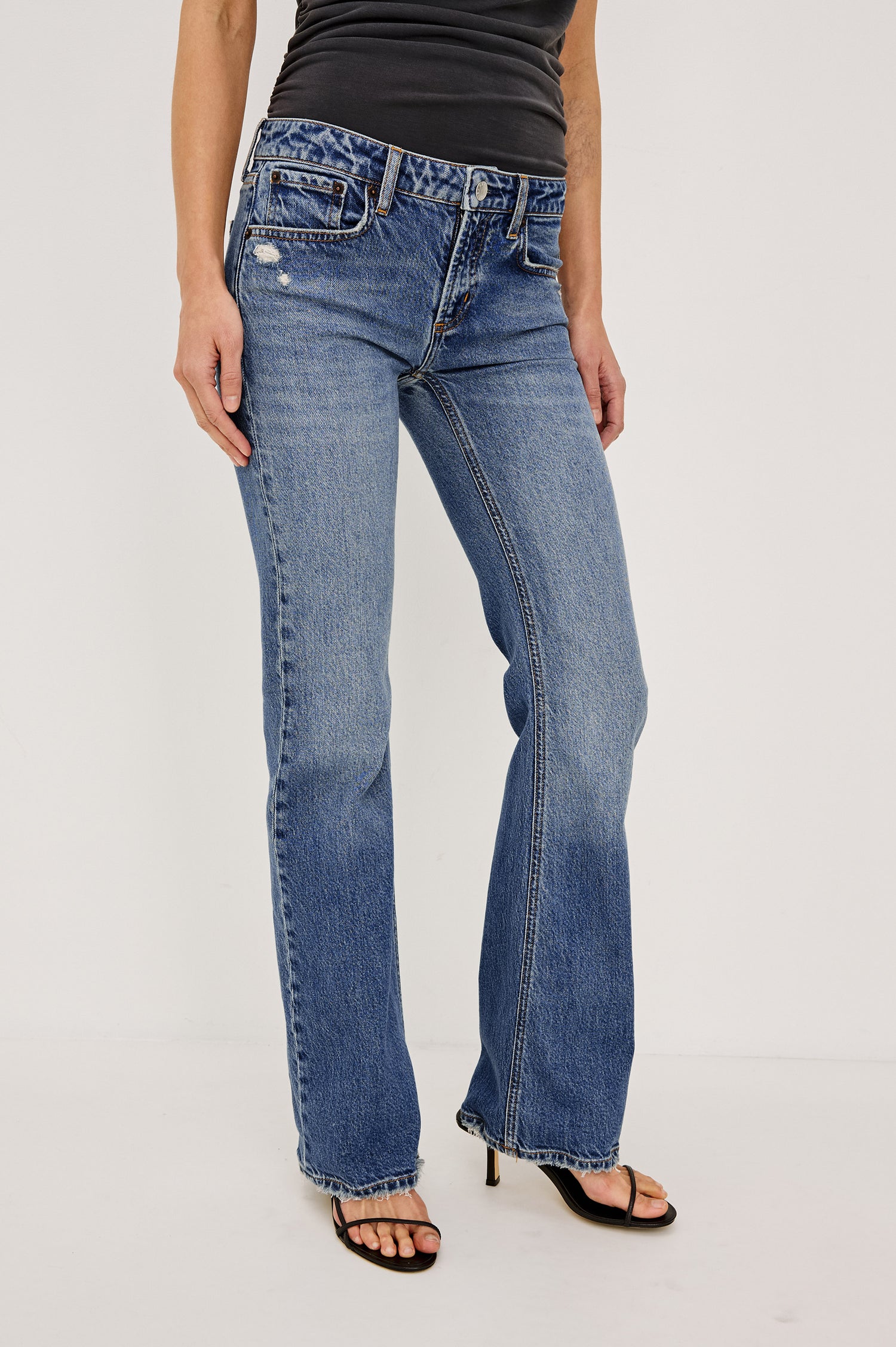Fremont Low Rise Bootcut Jean in Light Stretch Denim With Extended Inseam, 5-Pockets, Distressed Details, Belt Loops, and Zip-Fly Closure in Pioneertown Colorway - Lower Body Front View Featured on Model