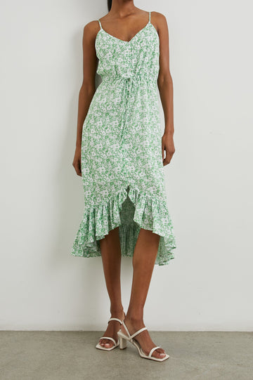 Frida Midi Dress with a Deep V Neck, Adjustable Spaghetti Straps, a Ruffled Hem, Drawstring Waist Ties and Buttons Down the Front in Green Texture Floral Colorway, Green and White Flowers - Front Full Body View Featured on Model