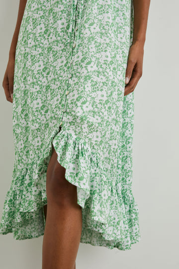 Frida Midi Dress with a Deep V Neck, Adjustable Spaghetti Straps, a Ruffled Hem, Drawstring Waist Ties and Buttons Down the Front in Green Texture Floral Colorway, Green and White Flowers - Front View Featured on Model