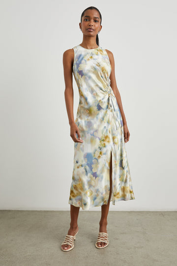 Gabriella Sleeveless Midi Dress with a Crew Neck, a Left Thigh Side Slit, a Ruched Drawstring on the Left Side and a Keyhole Button Closure at the Back in Diffused Blossom Colorway, Flowers in Golds, Creams and Blues on White - Front Full Body View Featured on Model 