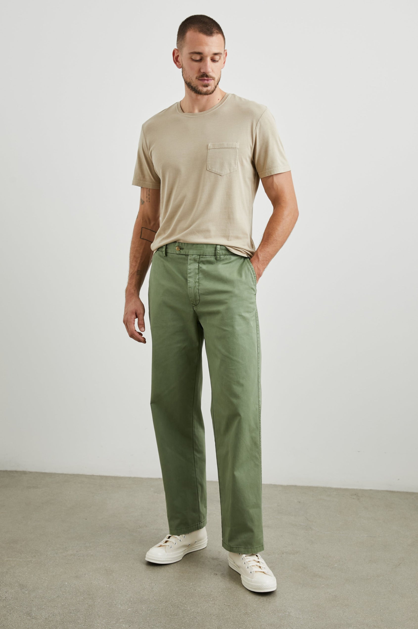 Garrett Pants with a Button Strap Closure at the Waist, Belt Loops, Two Front Pockets and Two Back Button Welt Pockets in Spring Olive Colorway - Front Full Body View Featured on Model