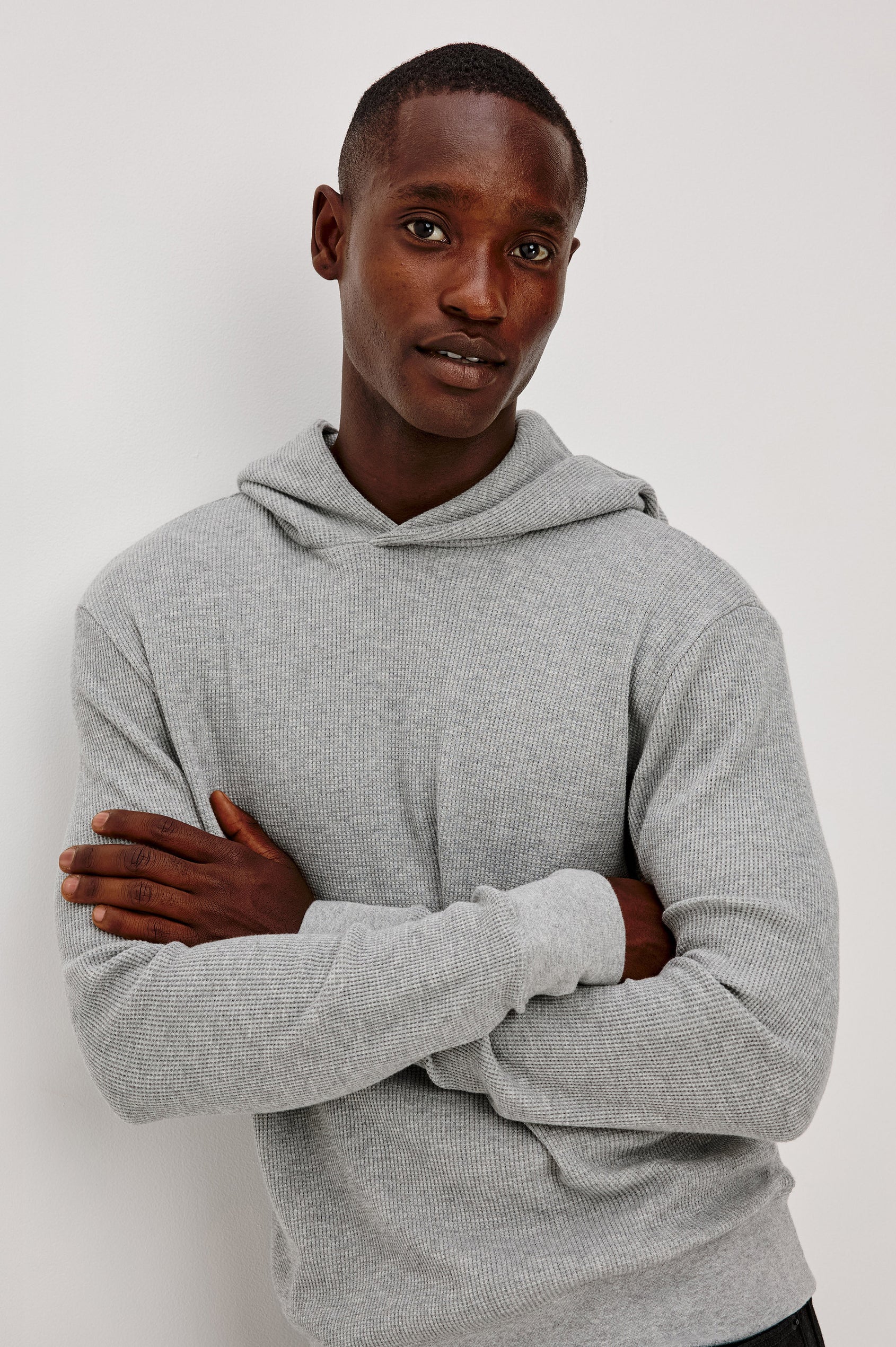 Gates Hoodie in Micro-Waffle Cotton Blend With Fixed Hood, Long Sleeves, and Relaxed Fit in Heather Grey Colorway - Upper Body Front View Featured on Model