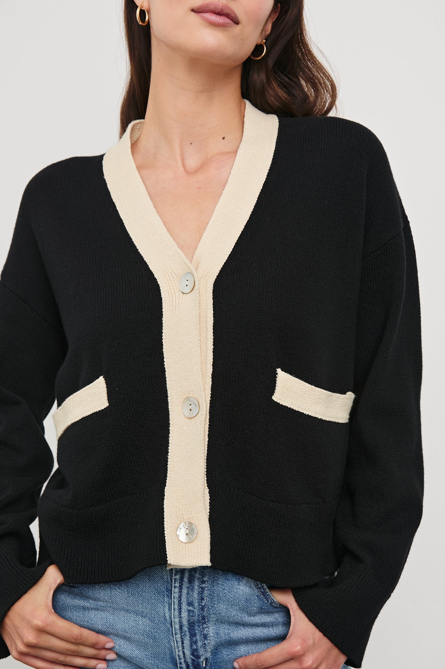 Geneva Long-Sleeve Cardigan with Two Front Patch Pockets and Button Closure in Black Ivory Colorway, with Ivory neckline, closure and pocket openings on Black - Front View Featured on Model