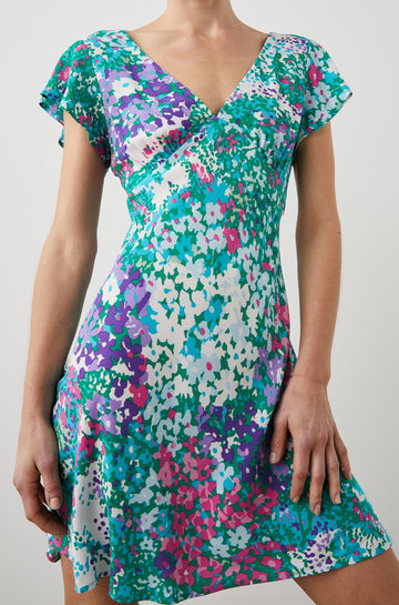 Gigi Short Sleeve Mini Dress with a Deep V Neck, and Flutter Sleeves in Gardenia Floral Colorway, Greens, Blues, Purples, Pink and White - Front View Featured on Model 