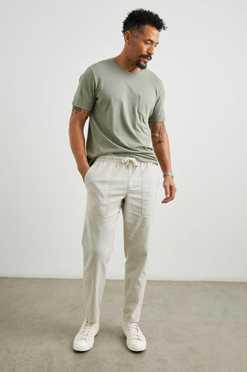 Gobi Pants with Drawstring Waist, Two Large Front Pockets and Two Back Buttoned Patch Pockets in Natural Colorway - Back View Featured on Model