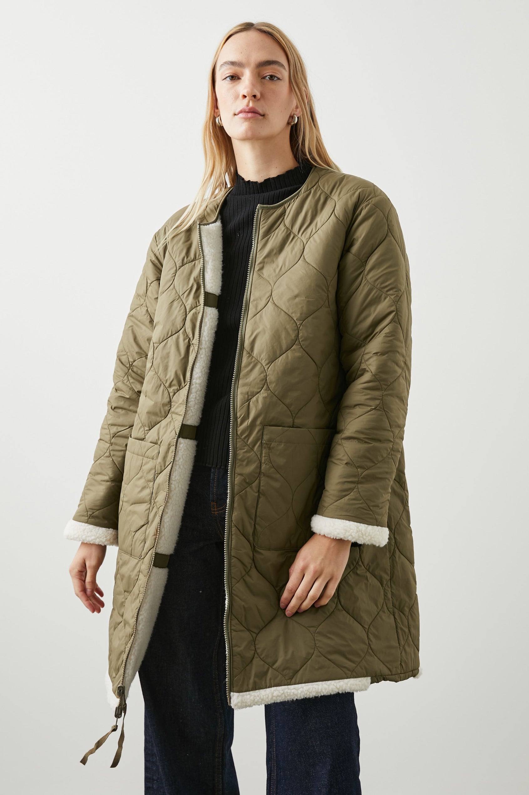 Granger Knee-Length Reversible Jacket with Zip Closure, One Side Quilted with Two Front Patch Pockets, the Reverse Side Ivory Sherpa Fleece with Olive Quilted Horizontal Bands in Ivory Olive Mix Colorway - Front Quilted View Featured on Model