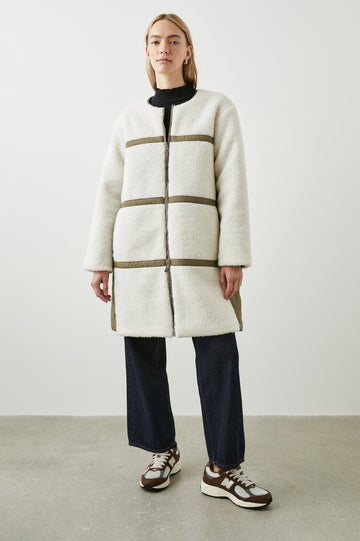 Granger Knee-Length Reversible Jacket with Zip Closure, One Side Quilted with Two Front Patch Pockets, the Reverse Side Ivory Sherpa Fleece with Olive Quilted Horizontal Bands in Ivory Olive Mix Colorway - Front Fleece Full Body View Featured on Model