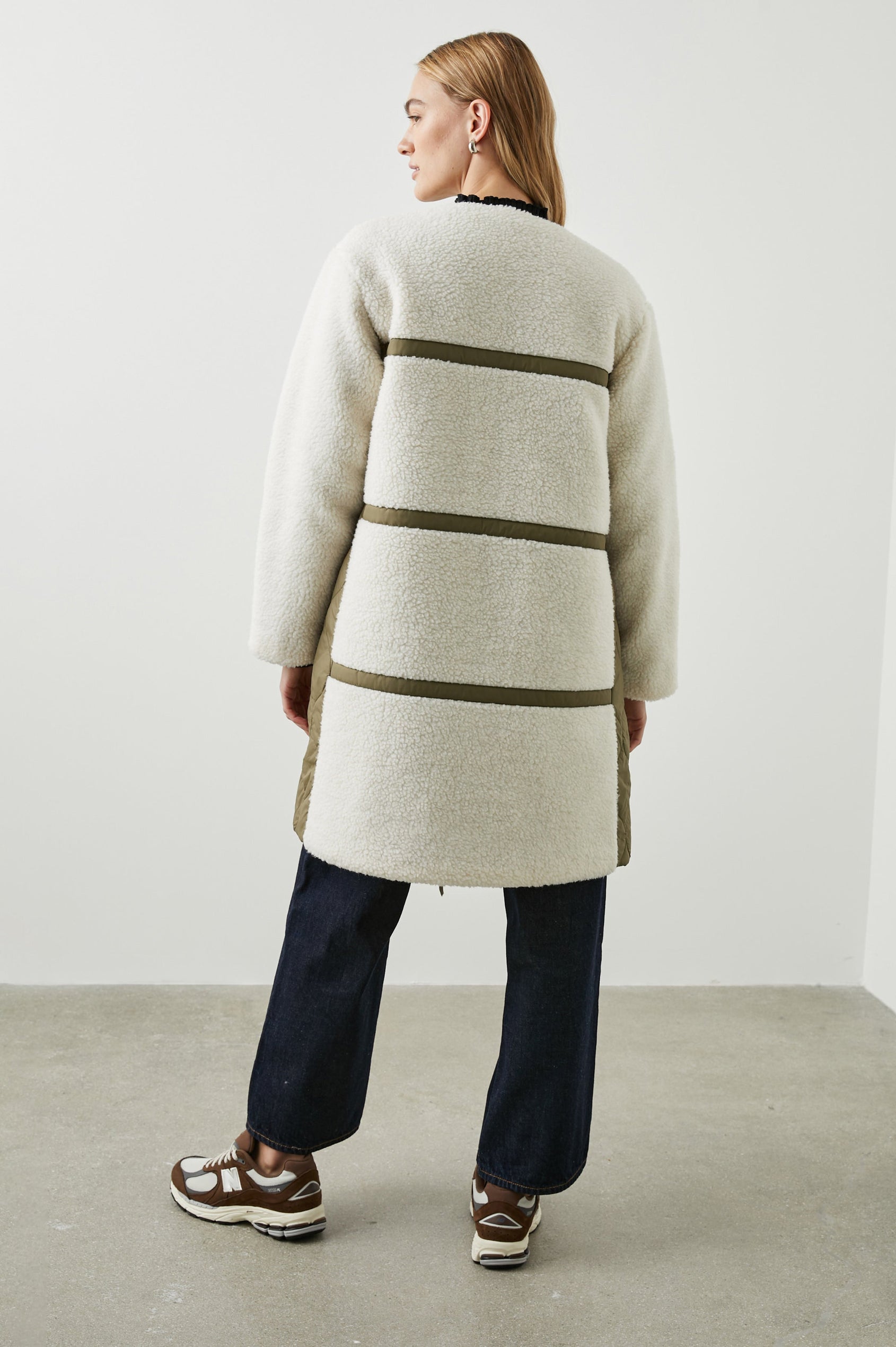 Granger Knee-Length Reversible Jacket with Zip Closure, One Side Quilted with Two Front Patch Pockets, the Reverse Side Ivory Sherpa Fleece with Olive Quilted Horizontal Bands in Ivory Olive Mix Colorway - Back Fleece Full Body View Featured on Model