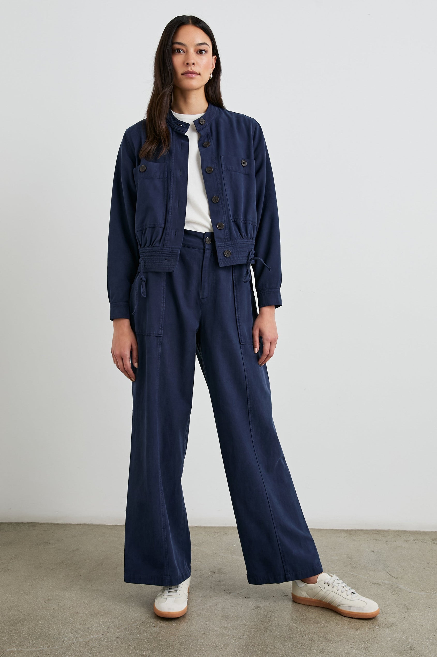 Greer Pants with Two Large Front Pockets, Two Back Welt Pockets and Vertical Seams Down the Front and Back Legs in Navy Colorway - Front Full Body View Featured on Model 