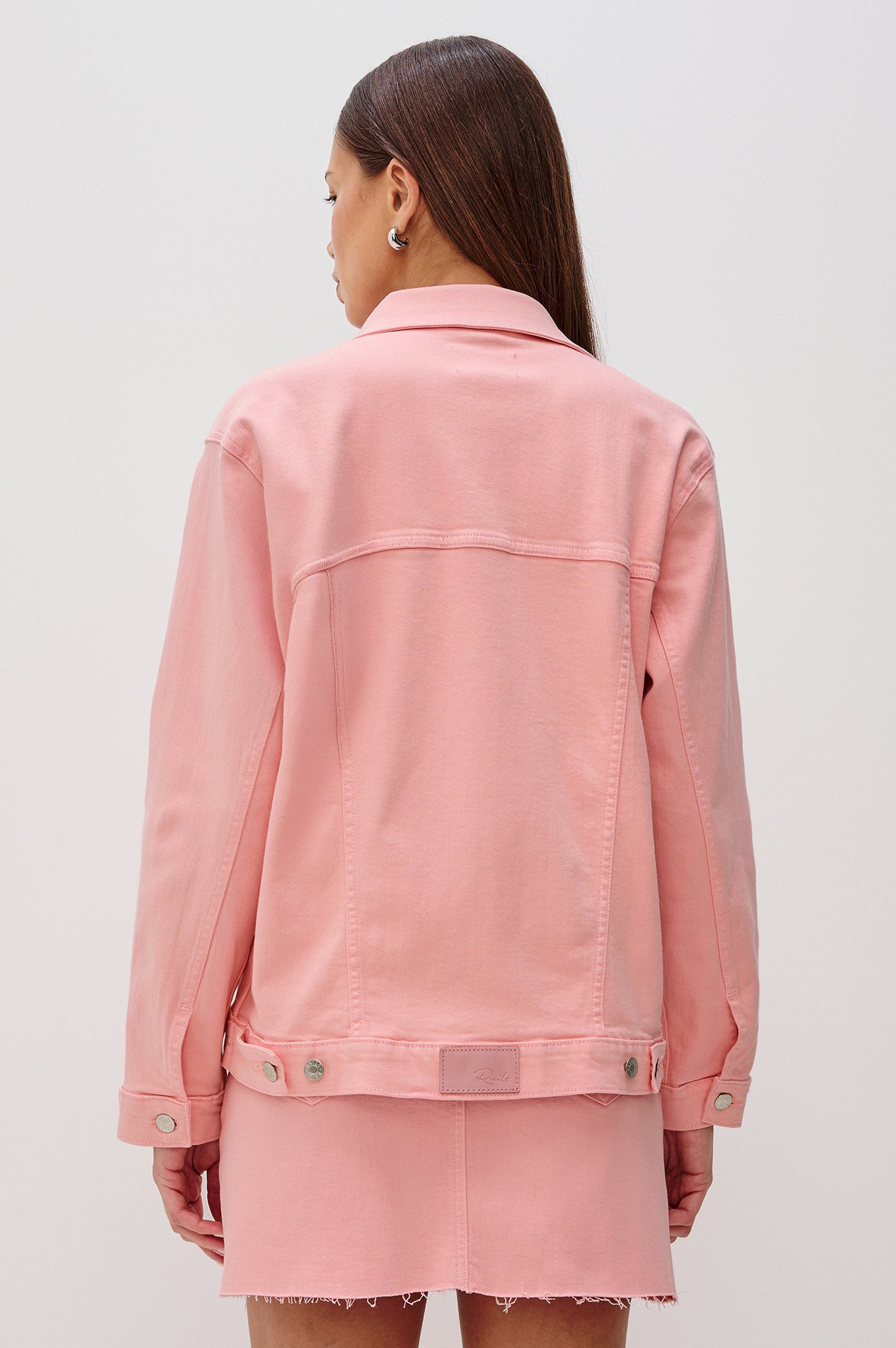 Grove Denim Trucker Jacket with Button Front and Chest Flap Pockets in Bubblegum Colorway. Back View of Model Shown.