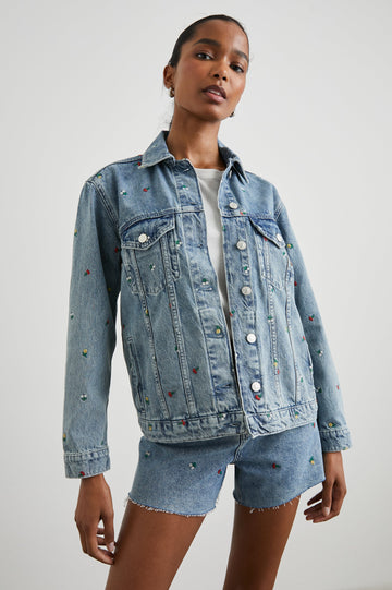 Grove Boyfriend Trucker Denim Jacket with Button Closure, Two Front Pockets, Two Chest Button Flap Pockets, Front Vertical Seams in Flower Field Colorway, with Embroidered Daisies in Yellow, Red and White - Front View Featured on Model  