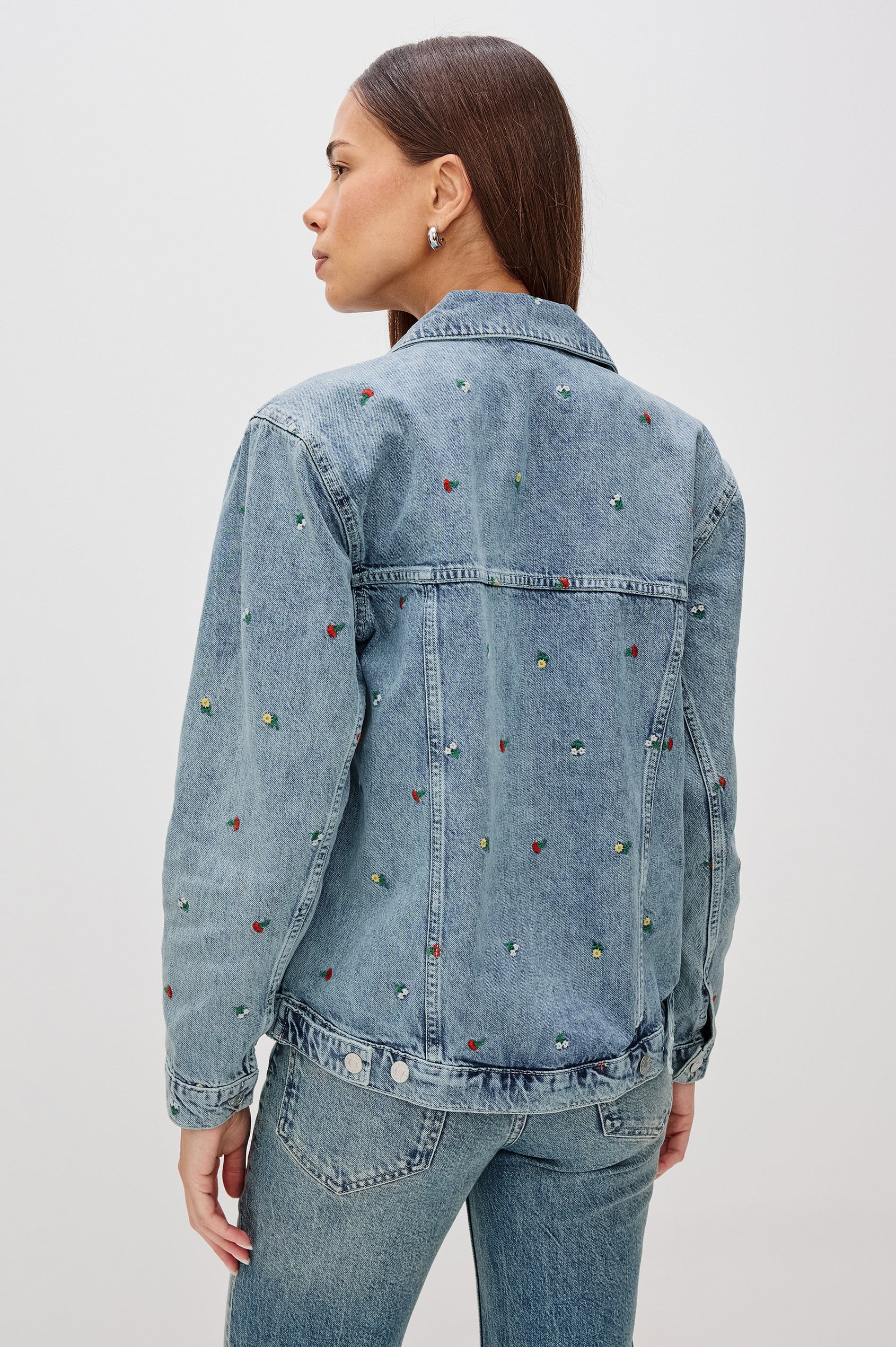 Grove Boyfriend Trucker Denim Jacket with Button Closure, Two Front Pockets, Two Chest Button Flap Pockets, Front Vertical Seams in Flower Field Colorway, with Embroidered Daisies in Yellow, Red and White - Back View Featured on Model  