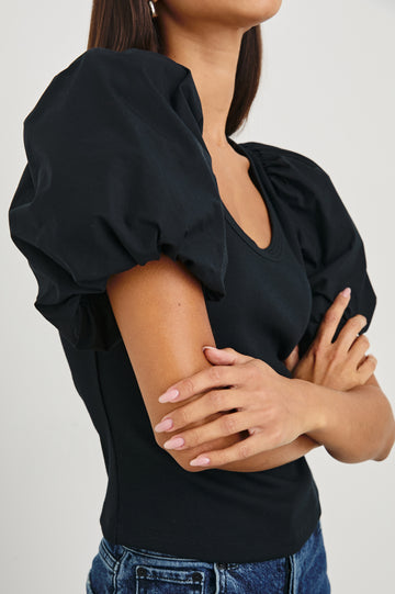 Hallie Short Sleeve Top with a Scoop Neck and Puff Sleeves in Black Colorway - Side View Featured on Model