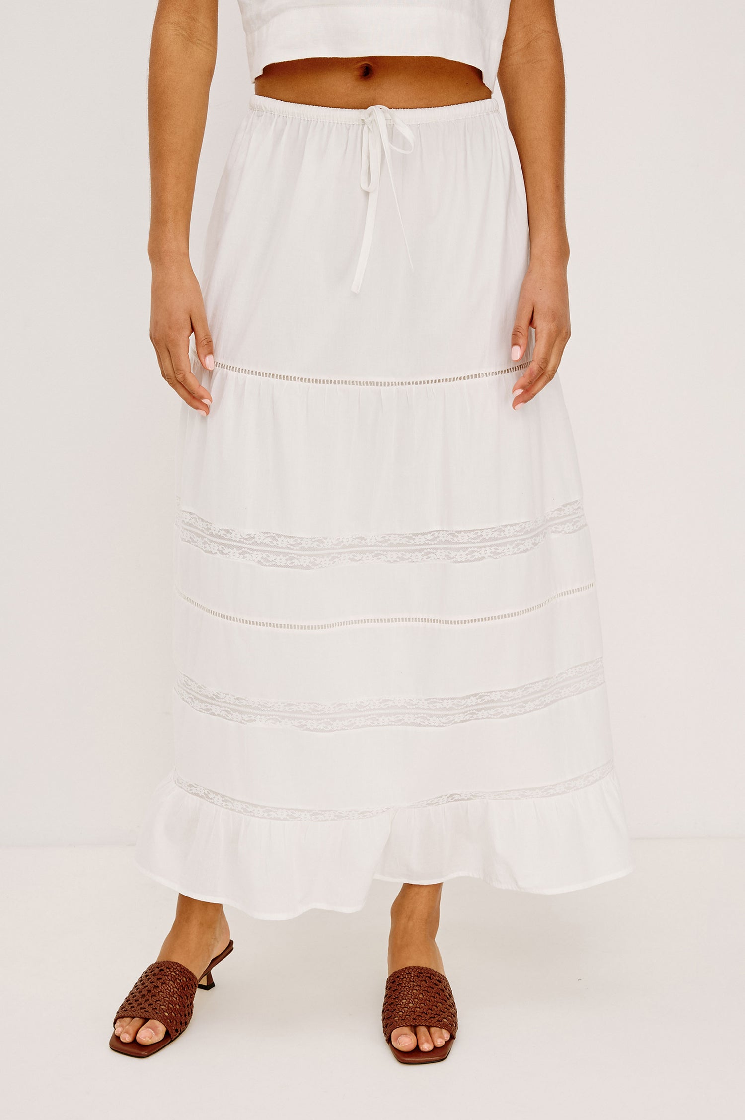 Hettie High-Waisted Maxi Skirt in Cotton Voile With Ladder Trim, Lace Insets, Self-Tie Waist, Relaxed Fit, and Fully Lined in White Colorway - Lower Body Front View Featured on Model