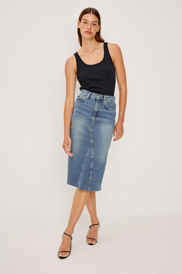 Highland Denim Midi Skirt with a Raw Hem, a Back Vent, Additional Front Seams, Belt Loops, Two Front Pockets plus a Coin Pocket and Two Back Patch Pockets in Vintage Sapphire Colorway - Front Full Body View Featured on Model 