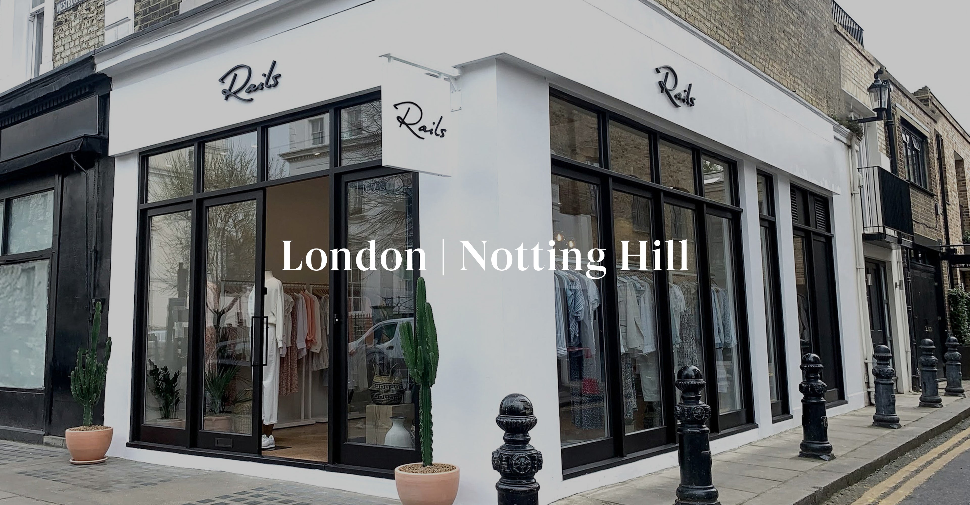OUTSIDE OF LONDON NOTTING HILL STORE SHOWING THE FRONT ENTRANCE (TWO LARGE GLASS DOORS) AND LARGE GLASS WINDOWS ON THE SIDE OF THE BUILDING