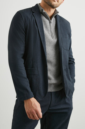 Idris Blazer with Two Button Closure, Two Front Patch Pockets, a Chest Patch Pocket and Three-Button Cuffs in Dark Navy Colorway - Front View Featured on Model
