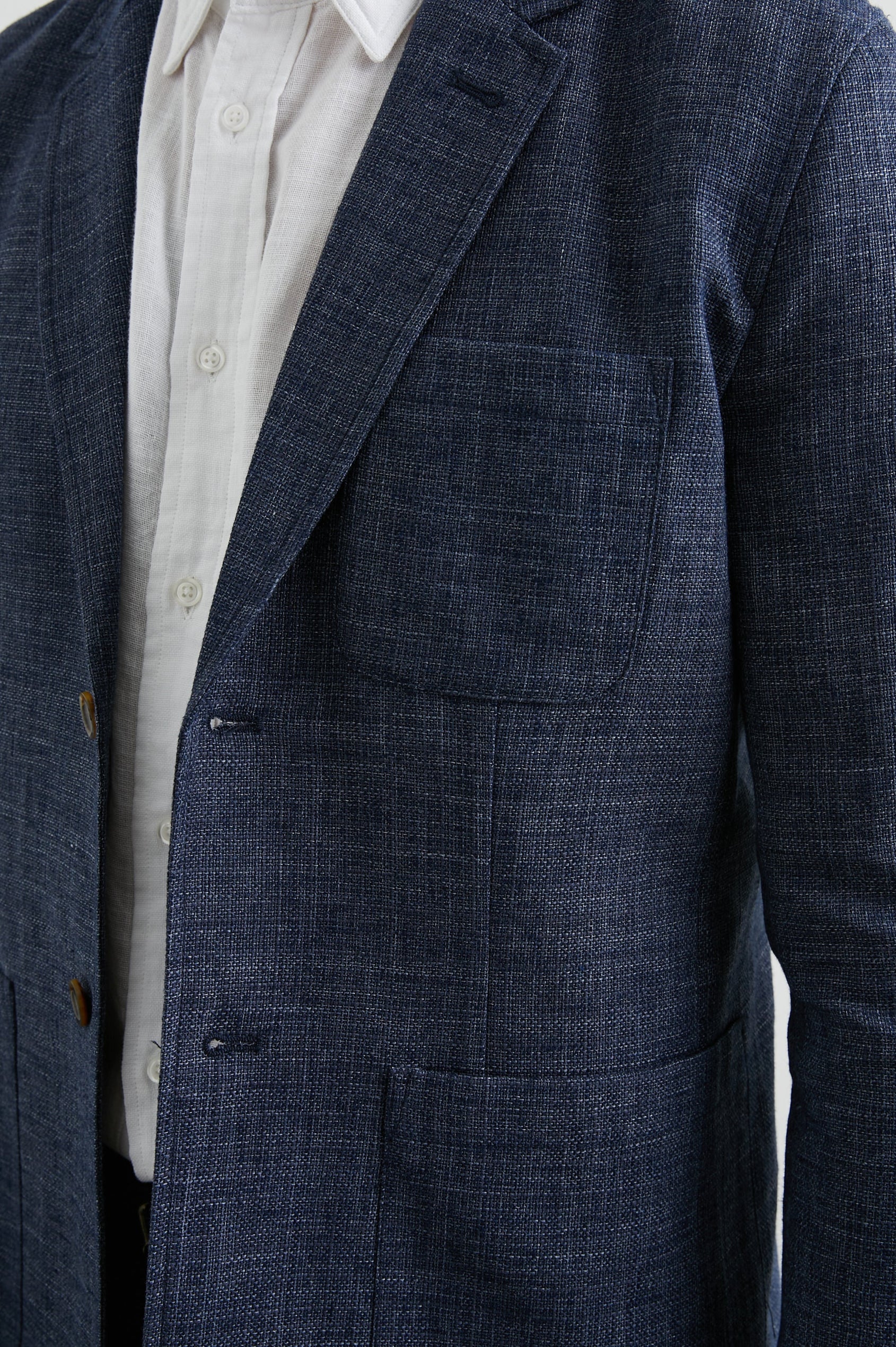 Idris Blazer with Two Button Closure, Two Front Patch Pockets, a Chest Patch Pocket and Three-Button Cuffs in Navy Melange Colorway - Front View Featured on Model