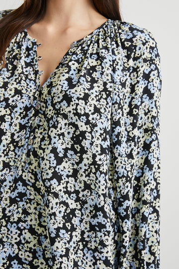 Indi Top with a V Neckline with a Button Placket, Pleating at Back Neckline and Elastic Cuffs in Midnight Meadow Floral Colorway, with cream and blue flowers on midnight - Front View Featured on Model