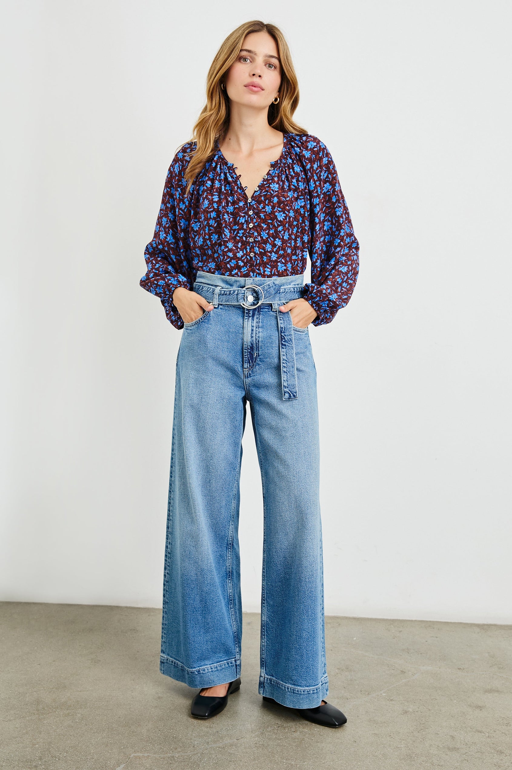 Indi Top with a V Neckline with a Button Placket, Pleating at Back Neckline and Elastic Cuffs in Russet Camellia Colorway, with russet and blue flowers - Front Untucked Ful Body View Featured on Model