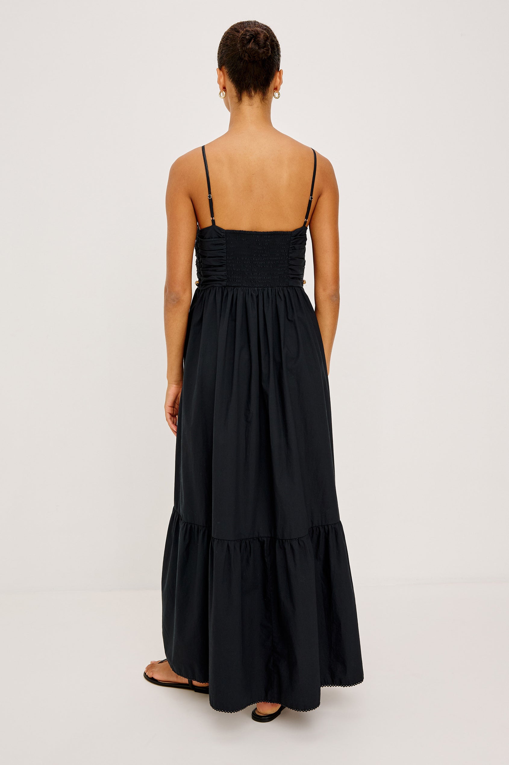 Ivana Maxi Dress in Cotton Poplin With Adjustable Spaghetti Straps, Ruched Bodice With Braided Trim and Beaded Embellishments, and Full Skirt in Black Colorway - Full Body Back View Featured on Model