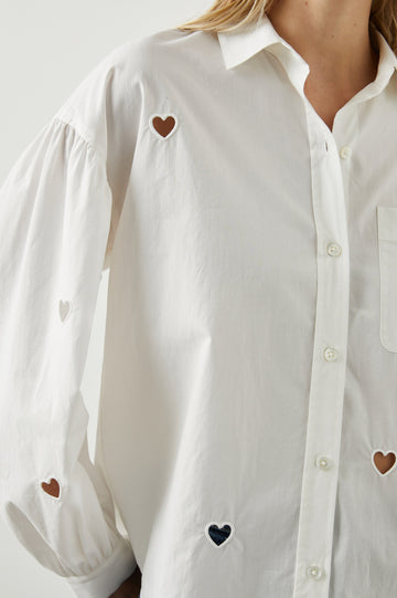 Janae Long Sleeve Button Up with a Chest Patch Pocket, Light Ruching at the Cuffs and Sleeve Shoulder and Cutout Hearts in White Eyelet Hearts Colorway - Front View Featured on Model 