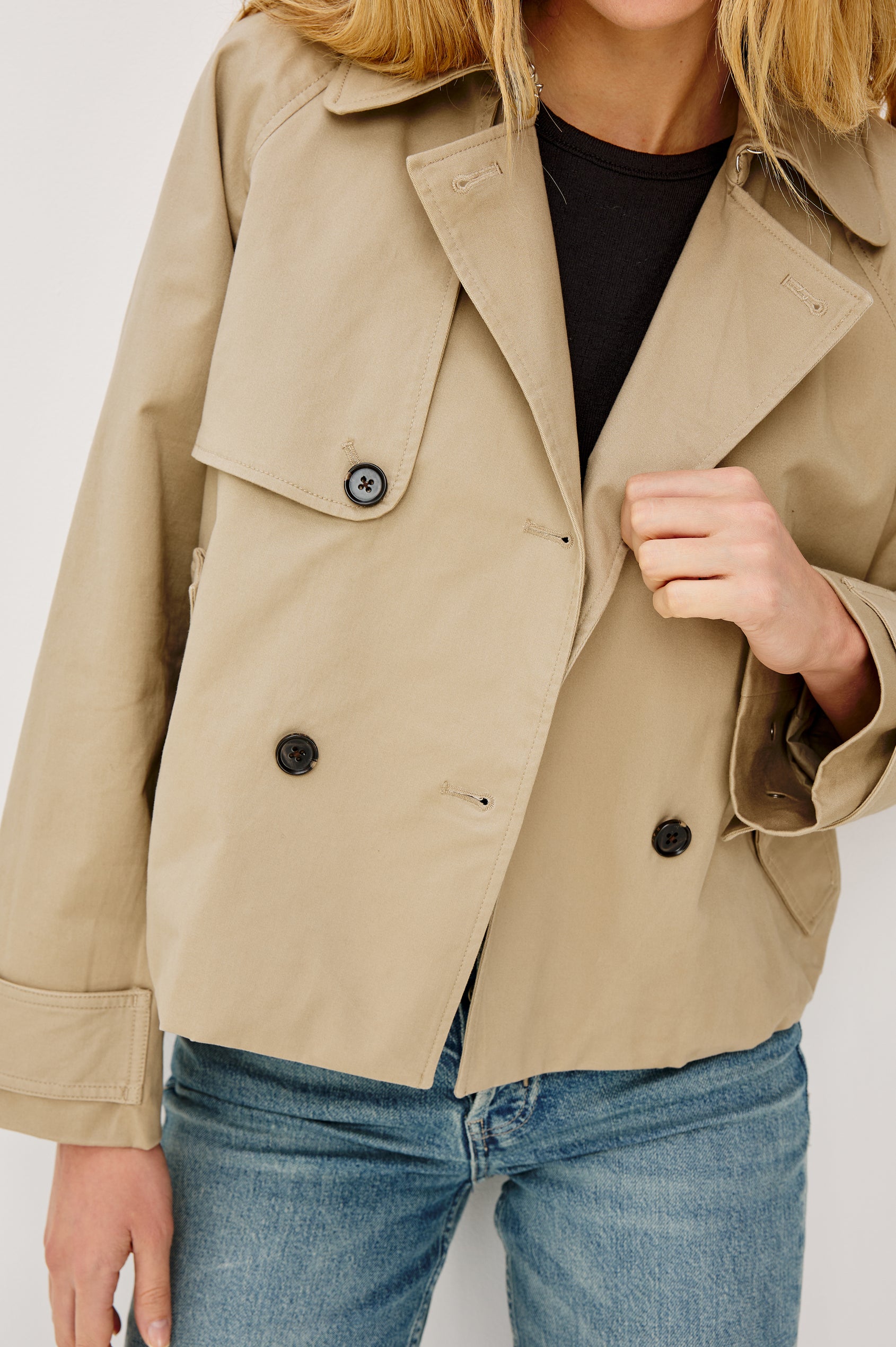 Jett Double Breasted, Cropped Trench Jacket, Lapel, Adjustable Cuff Belt, Side Pockets and Elasticated Hem in Taupe Colorway. Front Detail View Featured on Model.