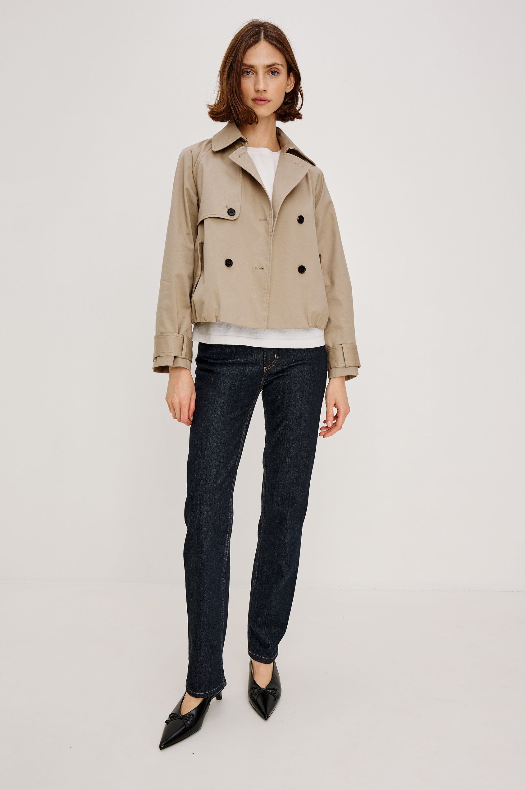 Jett Double Breasted, Cropped Trench Jacket, Lapel, Adjustable Cuff Belt, Side Pockets and Elasticated Hem in Taupe Colorway. Front Full Body View Featured on Model.
