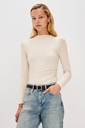 Joelle Long Sleeve Top with An Asymmetrical Mock Neck and Shirring on the Right Shoulder in Ivory Colorway - Front View Featured on Model