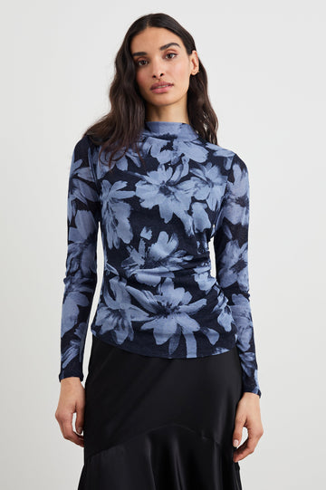 Joelle Long Sleeve Top with An Asymmetrical Mock Neck and Shirring on the Right Shoulder in Midnight Lily Colorway, with blue Lilies on Midnight - Front View Featured on Model