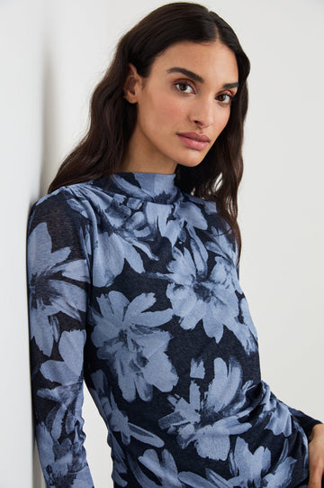Joelle Long Sleeve Top with An Asymmetrical Mock Neck and Shirring on the Right Shoulder in Midnight Lily Colorway, with blue Lilies on Midnight - Front View Featured on Model