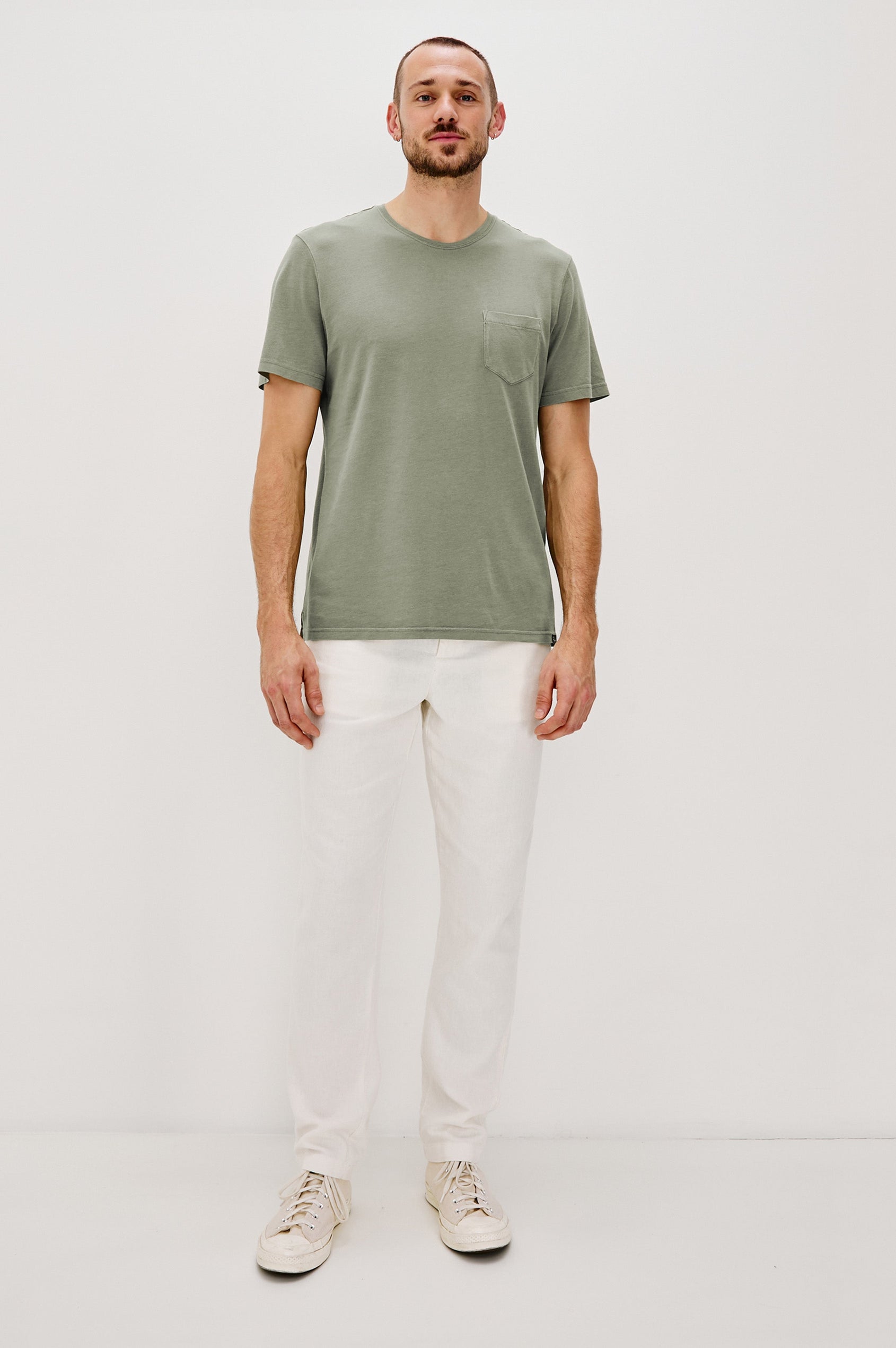 Johnny Short Sleeve T-Shirt with a Crew Neck, Chest Patch Pocket and Small Slits at the Side Hems in Olive Colorway - Full Body Front View Featured on Model