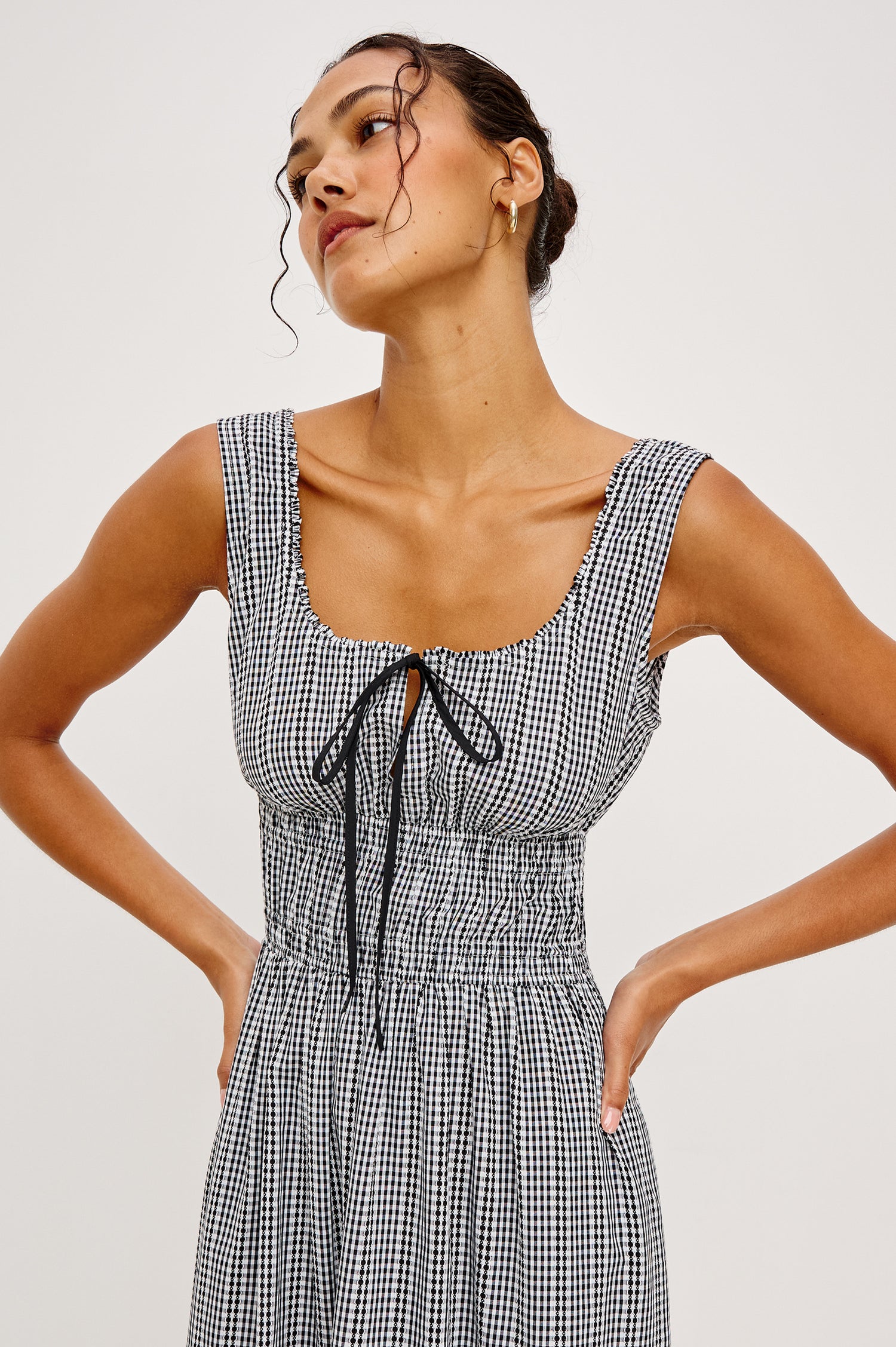 Jordie Maxi Dress in Cotton Poplin With A-Line Silhouette Rounded Square Neckline Rufle Trim Center-Front Bust Cutrout With Self-Ties Smocked Waist Side Pockets and Fully Lined Skirt in Black Gingham Colorway - Upper Body Front Close Up View Featured on Model