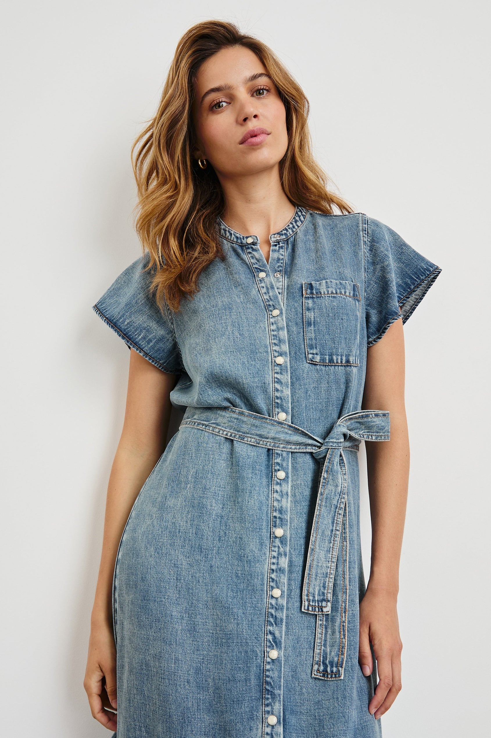 Kahlo Short-Sleeve Midi Dress with Snaps Down the Front, a Waist Tie, a Chest Patch Pocket and a Pleated Hem in Mid Blue Colorway - Front View Featured on Model