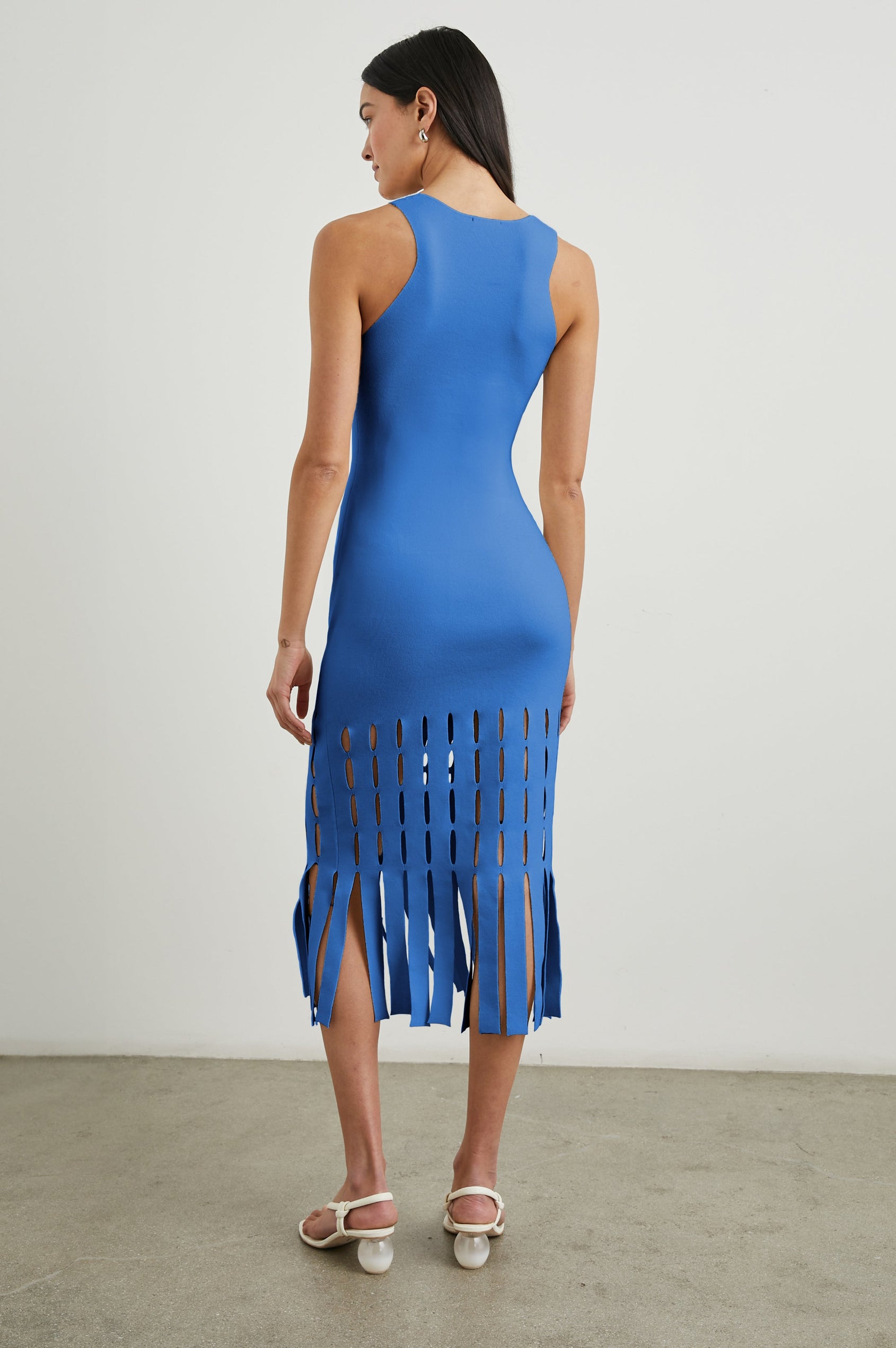 Kaia Sleeveless Midi Dress with a V Neck and Vertical Dashed Cutouts From the Thigh Downward, ending in Panels in Sapphire Colorway - Back Full Body View Featured on Model