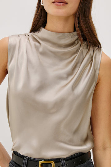 Kaleen Sleeveless Top with Mock Neck with Buttons and Keyhole on the Back and Draped Fabric on the Upper Chest in Mink Colorway - Front Close Up View Featured on Model