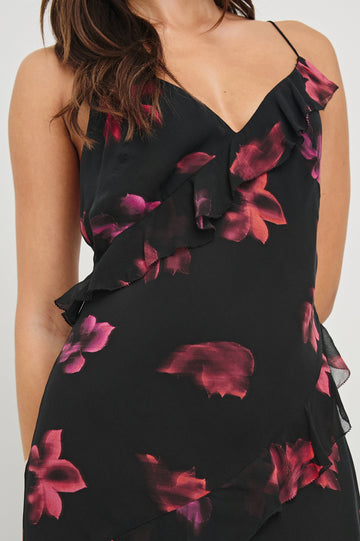 Kariselle Sleeveless Maxi Dress with Adjustable Spaghetti Straps, a Deep V Neck and Diagonal Ruffling in Dark Azalea Colorway, flowers in pinks on Black - Front  View Featured on Model