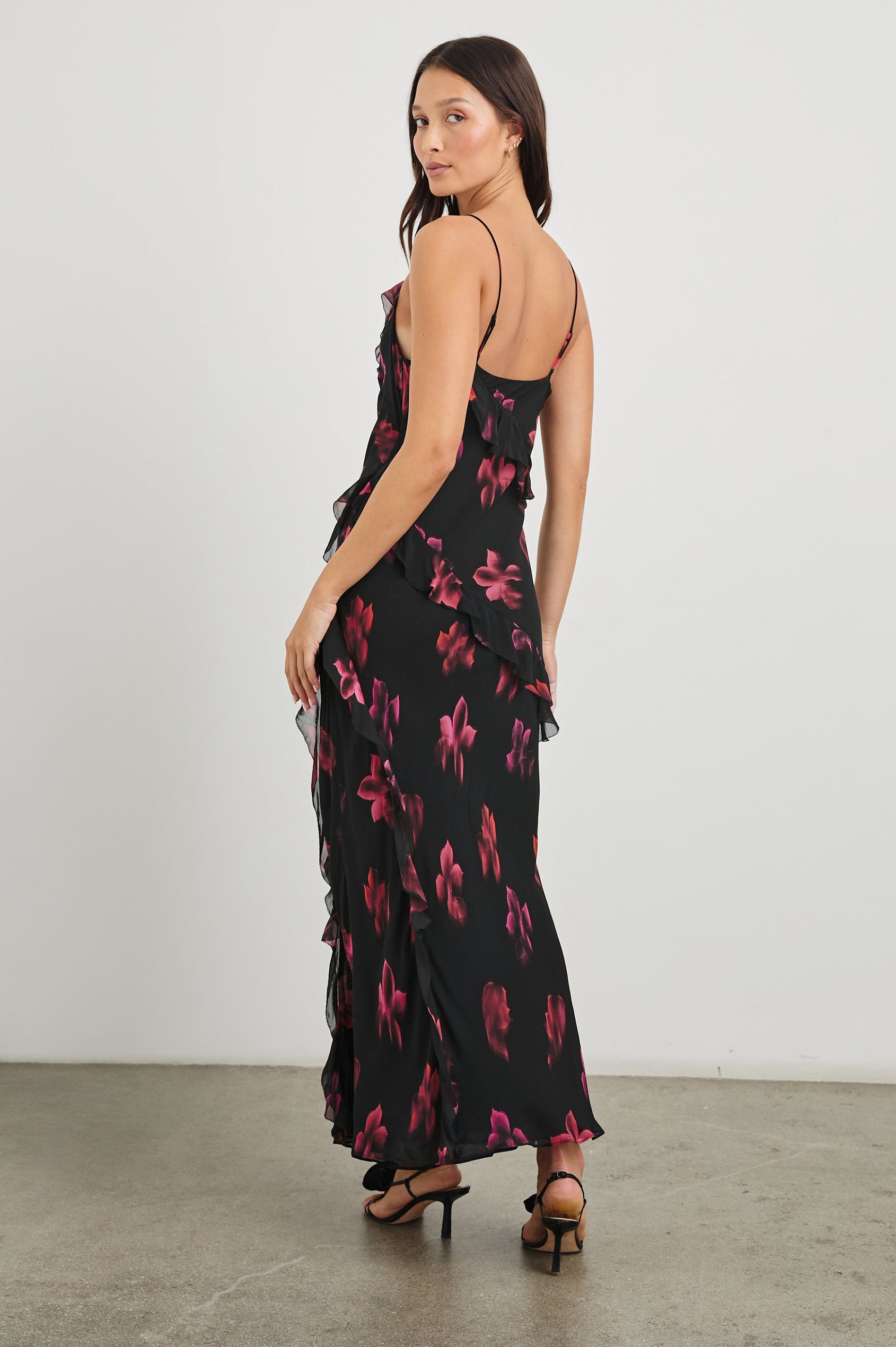 Kariselle Sleeveless Maxi Dress with Adjustable Spaghetti Straps, a Deep V Neck and Diagonal Ruffling in Dark Azalea Colorway, flowers in pinks on Black - Back Full Body View Featured on Model
