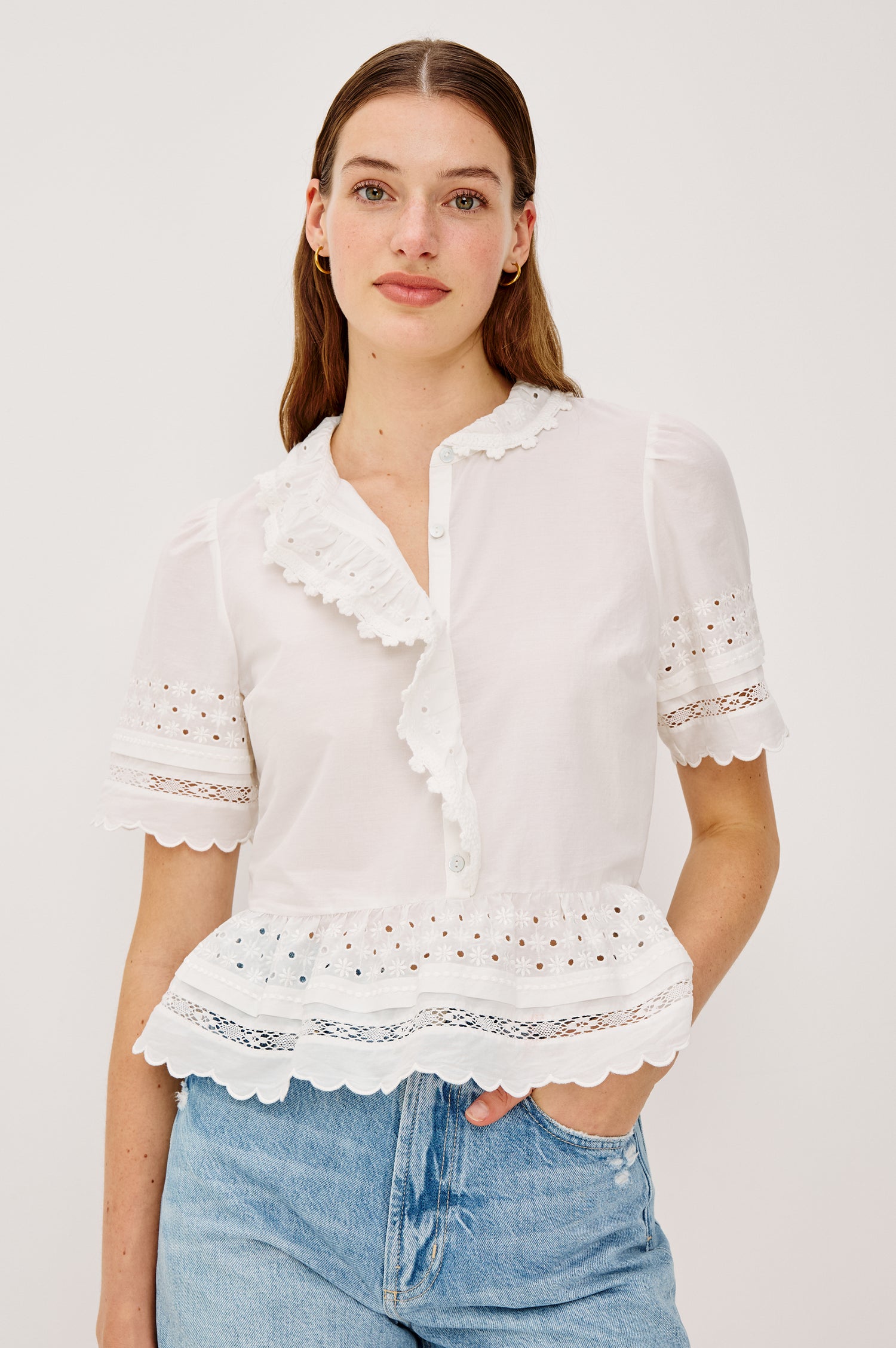 Keeta Shirt in Lightweight Beach Cotton With Ruffled Peter Pan Collar Front Placket Short Sleeves Tiered Hem Crochet Eyelet and Scalloped Trim in White Colorway - Upper Body Front View Featured on Model